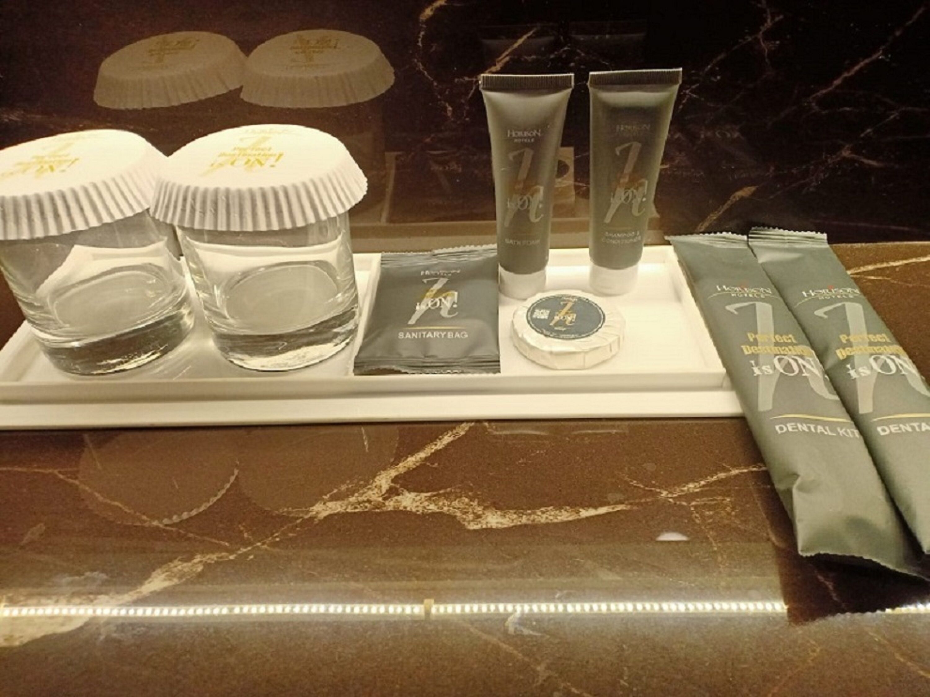 Una bandeja con productos de higiene bucal, incluyendo cepillos de dientes, pasta dental y un kit dental.