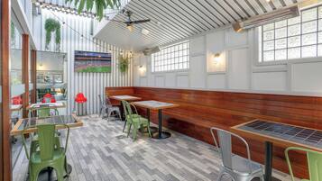 A restaurant with wooden booths, green chairs, and a tiled floor.