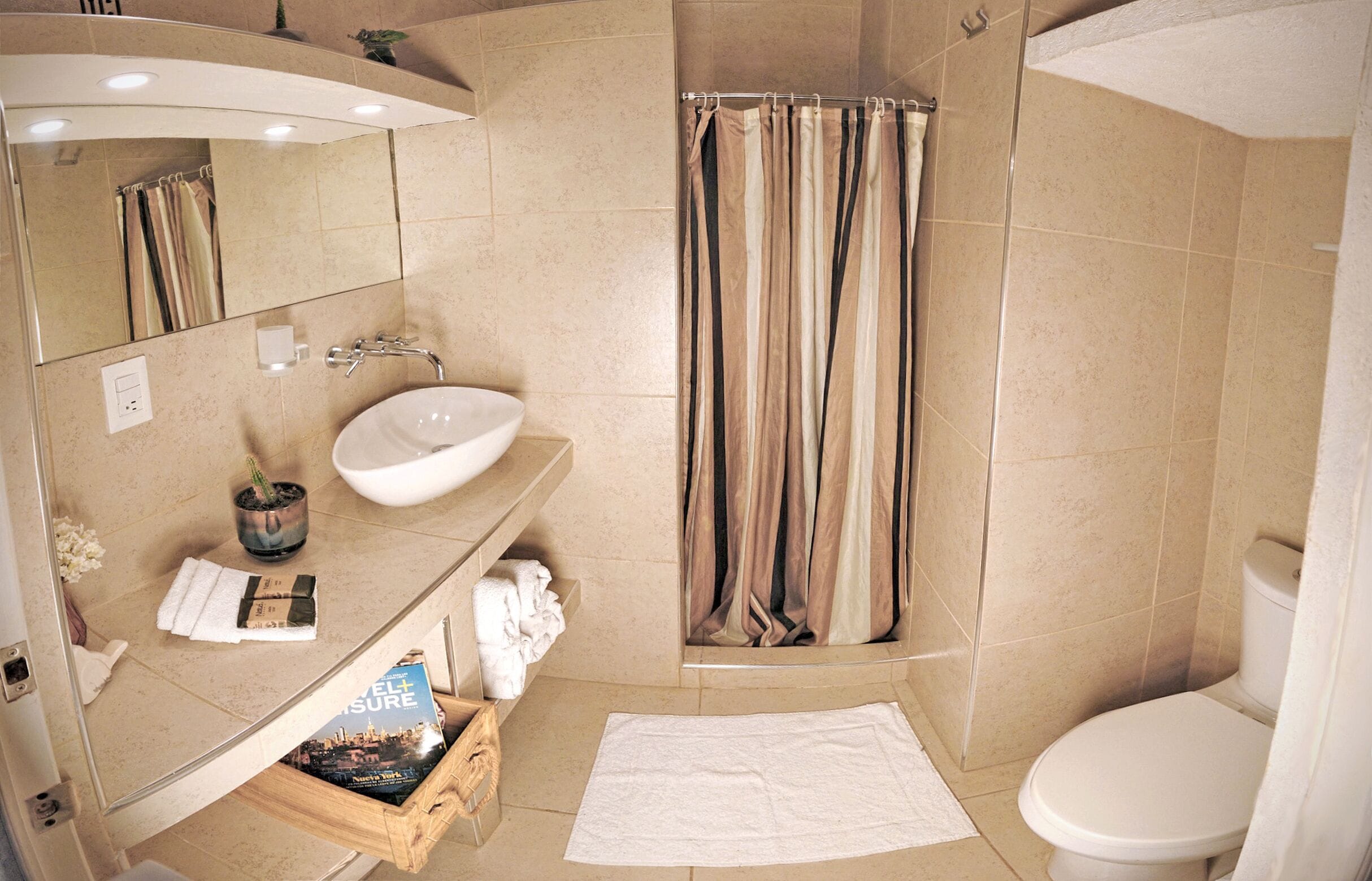 A modern bathroom with a sink, mirror, and shower curtain.