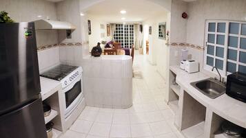 Una cocina moderna con una isla central, horno empotrado y un refrigerador de acero inoxidable.