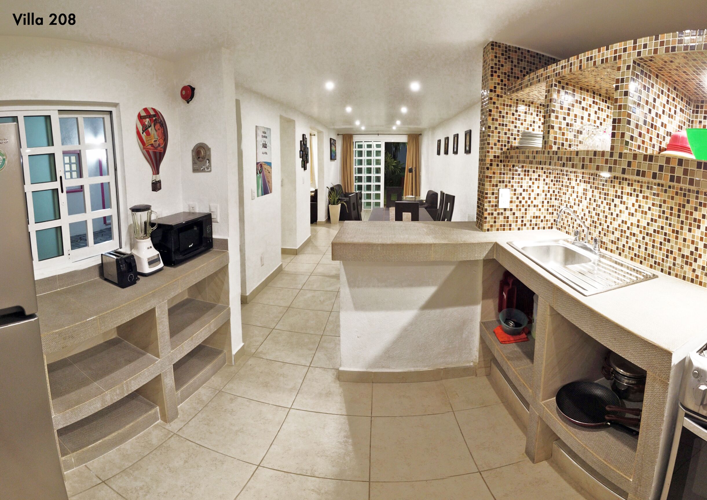 A compact kitchen with a central island, a dining area, and a view of the dining room.