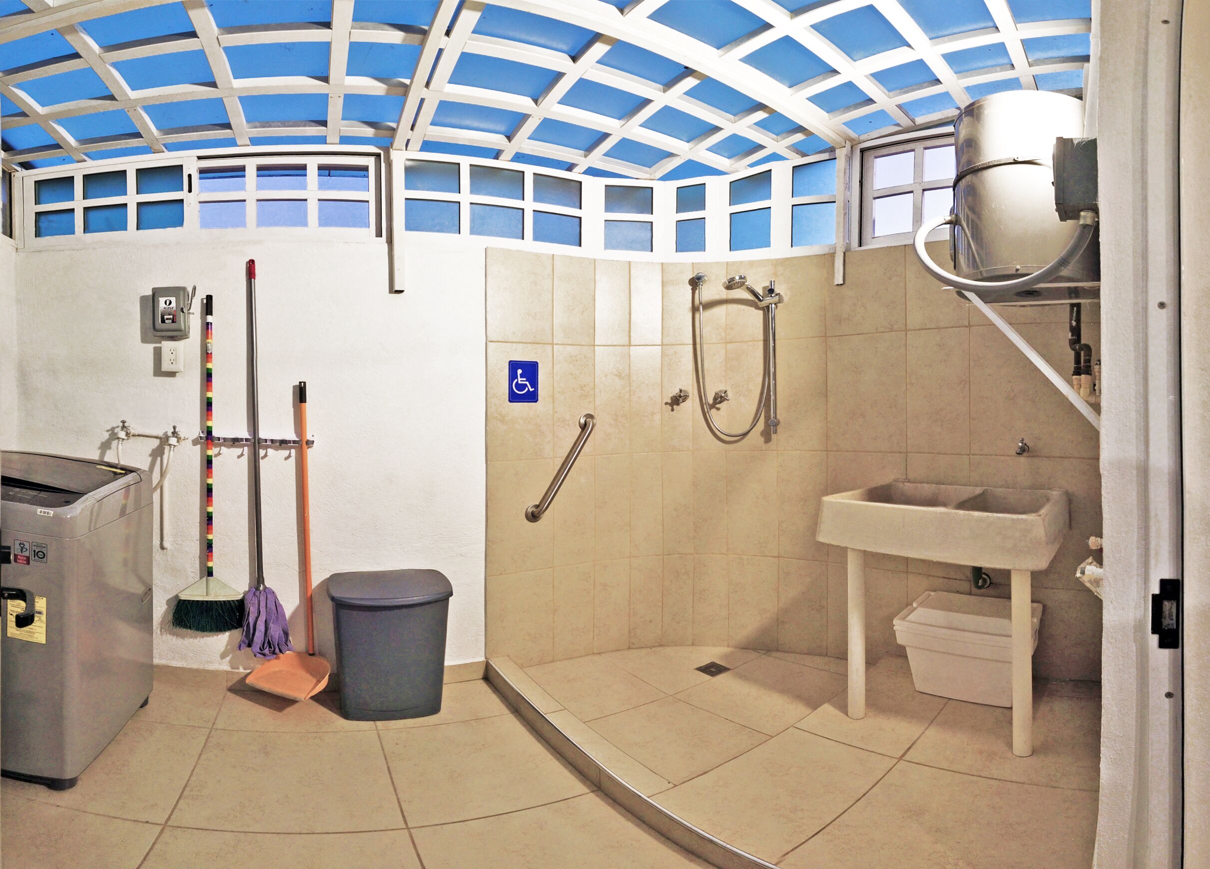 A bathroom with a shower, sink, and a hand dryer.