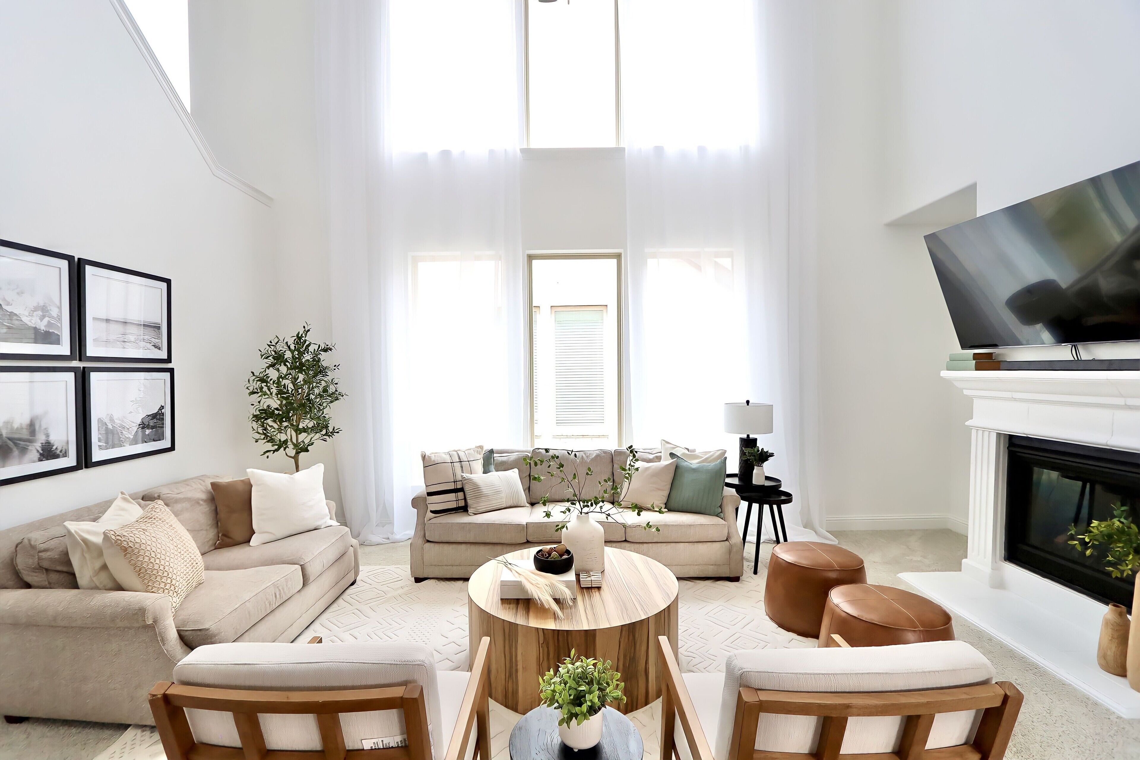 A living room with a sofa, armchairs, a coffee table, and a television.