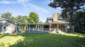 A two-story house with a covered porch, a brick chimney, and a well-maintained lawn. - 4BR Cozy Home, Close to UGA & Downtown Athens (Athens)