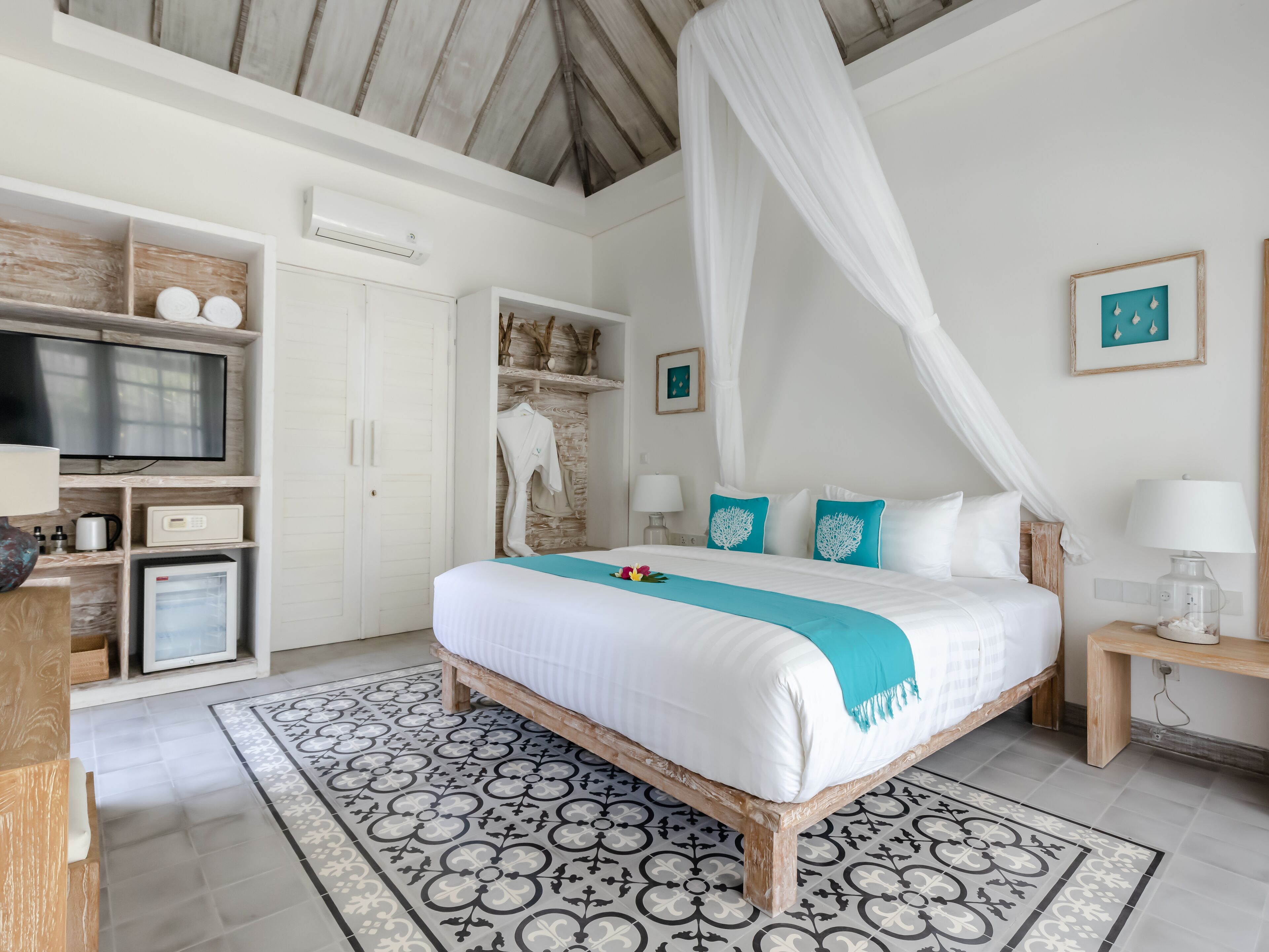 Un dormitorio con cama, televisor, armario y baño.