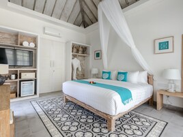 Un dormitorio con cama, televisor, armario y baño.