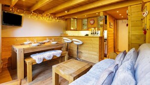 Un intérieur en bois comprenant un espace repas, un bar et des sièges.
