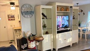 A living room with a leather sofa, a wooden coffee table, a television, and a white cabinet with shelves. - Water Front/ Lake Okeechobee Access in Buckhead Ridge (Okeechobee)
