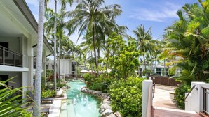 A resort with a swimming pool surrounded by palm trees and a wooden deck. - Seascape Holidays at Seascape Temple - Studio (Douglas)