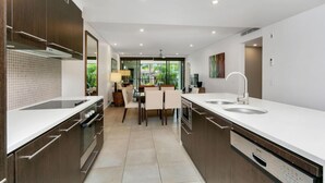 Une cuisine moderne dotée d’un îlot central, d’un four encastré et d’un lave-vaisselle.