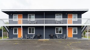 A two-story building with a balcony, two doors, and two outdoor seating areas. - AquaShores#3 - Pet friendly, BBQ grill & free Wifi (Ocean Shores)
