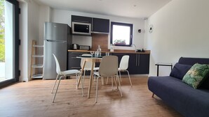Uma cozinha moderna com área de refeições, um sofá e uma janela que oferece luz natural.