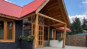 Un edificio con techo rojo, fachada de madera y ventanas grandes.