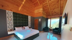 Un dormitorio espacioso con una cama grande, techo de madera y vistas al exterior.