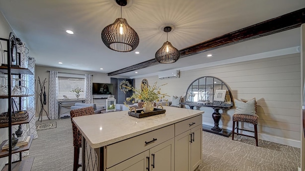 A spacious kitchen with a central island, pendant lighting, and a dining area with a table and chairs. -  Luxury Town Square Condo king Bed & W/D (Blairsville)