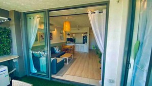 A modern living room with a sofa, coffee table, and a dining area with a table and chairs. - New Modern Deco' Apartment - Ocean View (Surfers Paradise)