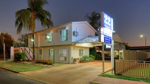 A two-story motel with a sign indicating it is number 22. - 22 on Bowen Motel (Roma)