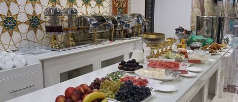 A buffet setup with various fruits, vegetables, and a beverage station.