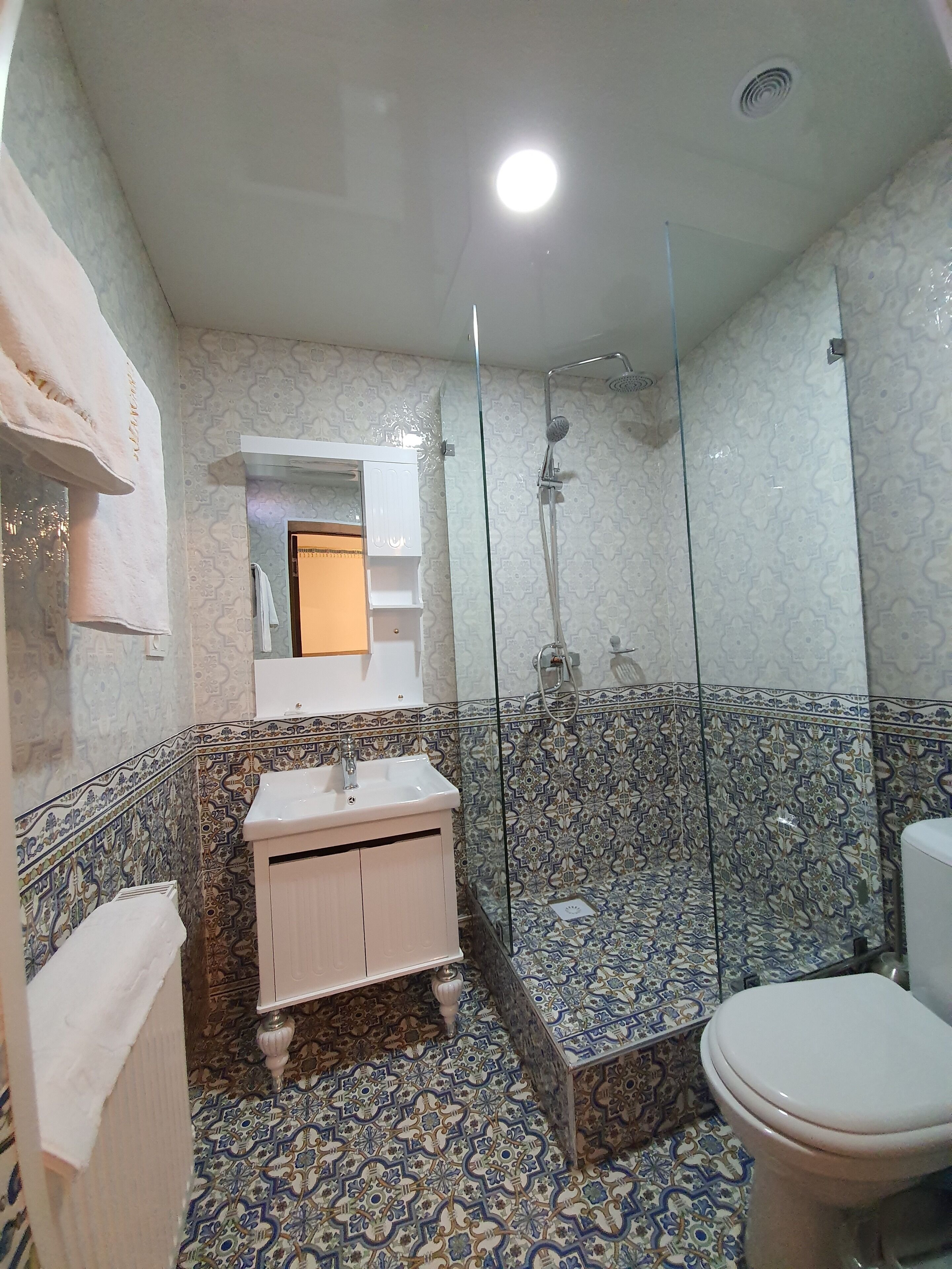 A bathroom with a white sink, a toilet, and a shower area.