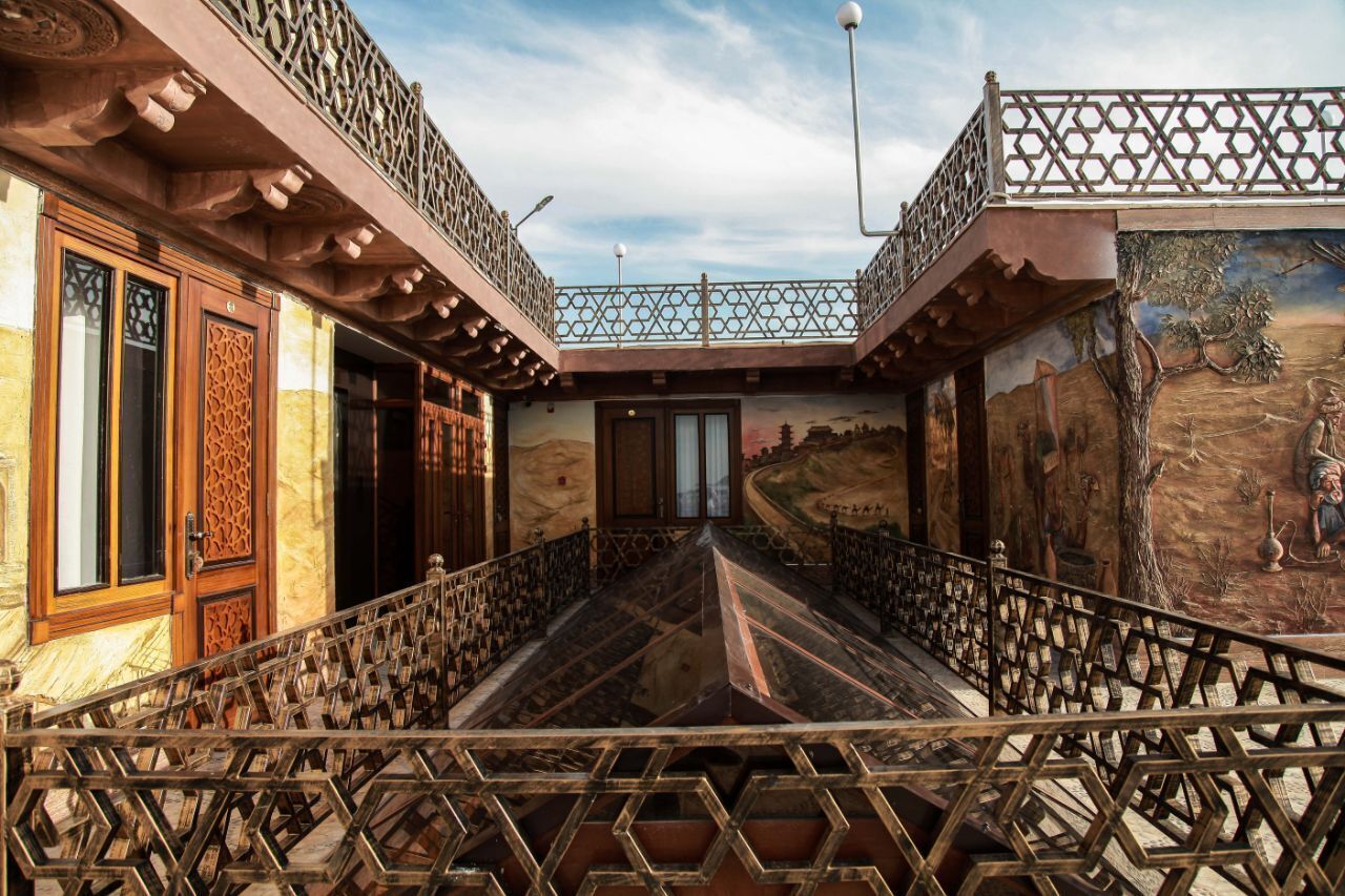Un bâtiment doté d’un balcon, d’une fresque murale et d’une porte ornée de sculptures complexes.