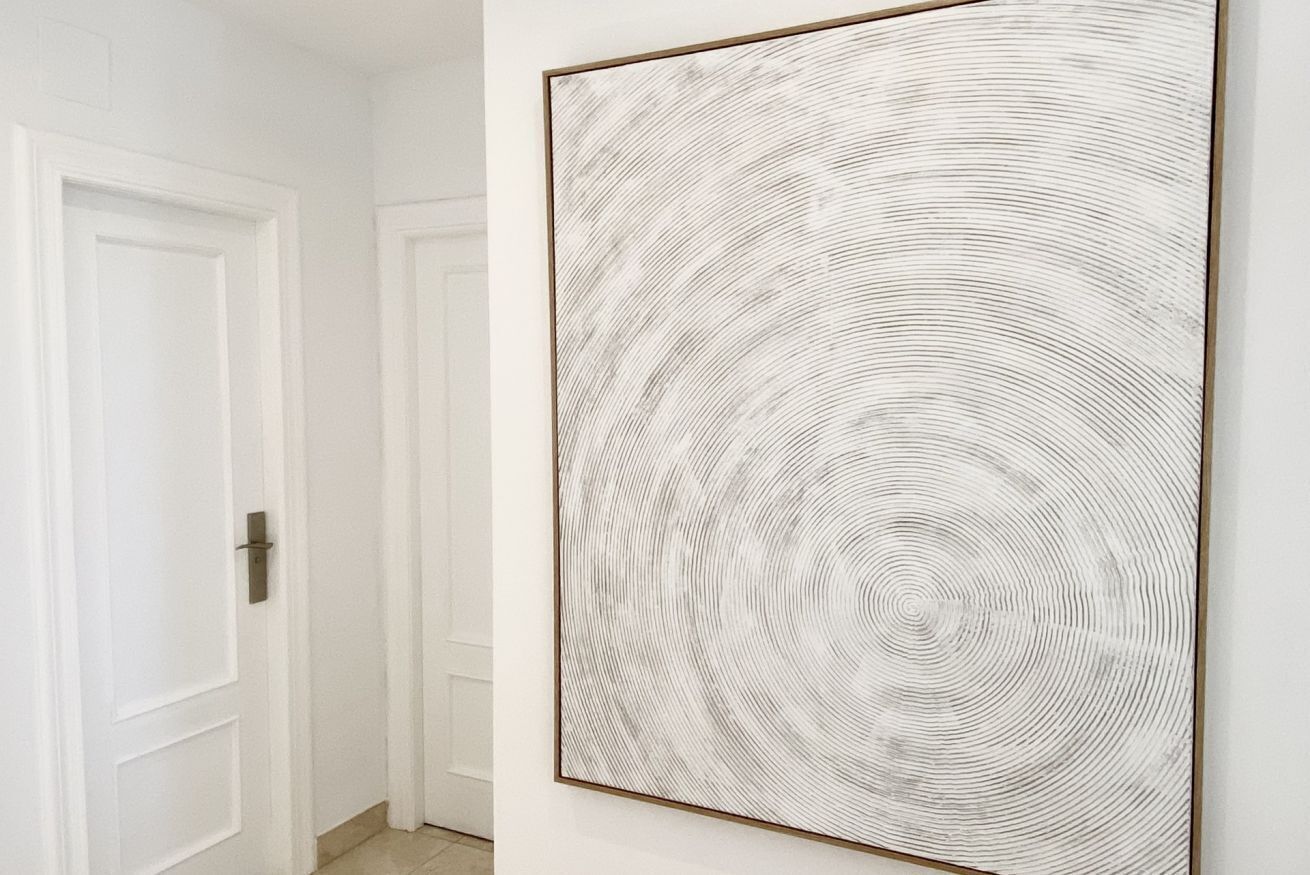 Un couloir orné d’une grande œuvre d’art à la texture particulière.