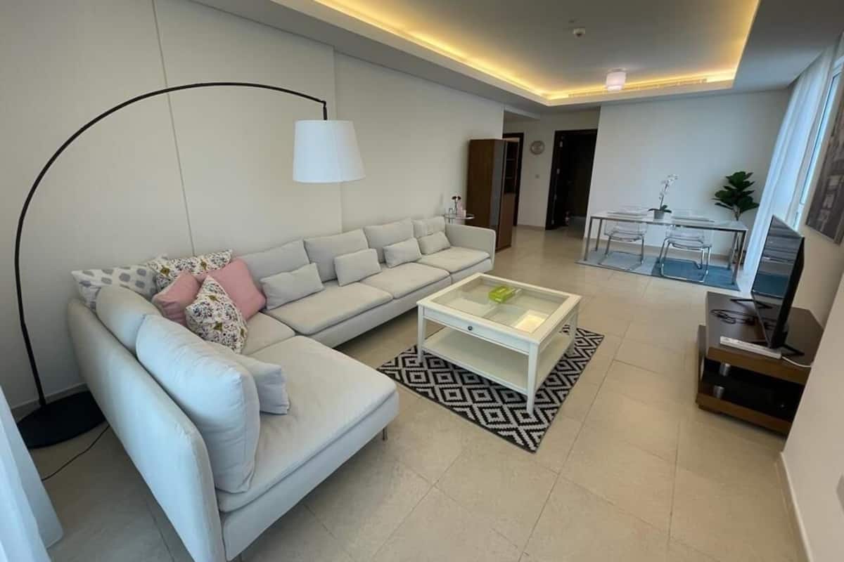 A modern living room with a sofa, coffee table, and a TV stand.