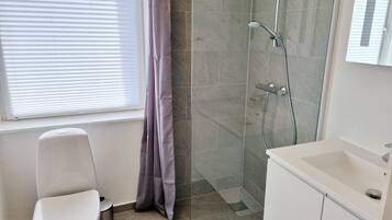 Un baño con inodoro, ducha y lavabo.