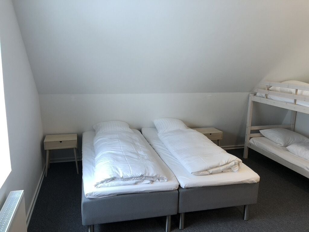 Ein Doppelzimmer mit zwei Betten, einem Fenster und einer Heizung.