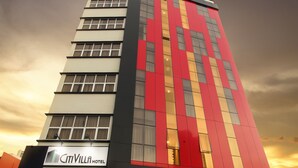 Un hotel alto dal design moderno, con una facciata importante in rosso e beige.