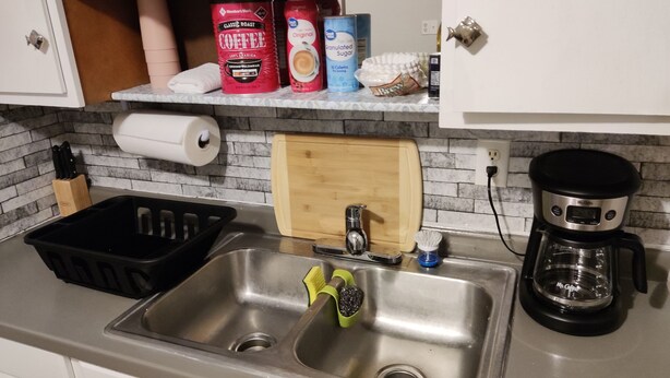 A kitchen with a stainless steel sink, a coffee maker, and various coffee products on the countertop. - 1-bedroom private home just 4 minutes to Lucas Oil Stadium (Indianapolis)