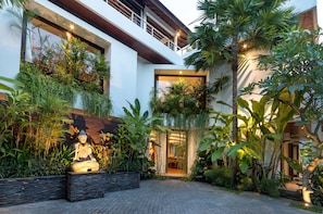 Welcome to a serene retreat, surrounded by lush greenery and a tranquil Buddha statue.