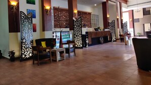 A spacious lobby with wooden beams, a reception desk, and seating areas. - TGN SUITS - HOTEL (Raipur)