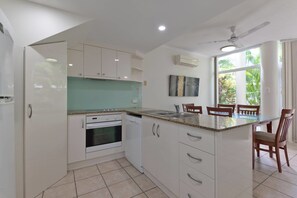 Enjoy cooking in this well-equipped kitchen with an oven, sink, and dining area.
