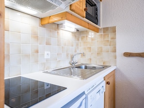 A kitchen with a dishwasher, a sink, and a microwave. - Bright studio with balcony, Ski-in/Ski-out, 4 pers (Les Menuires)