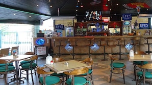 A restaurant with booths and tables, a bar area, and a sign for 'EFES Pilsen'. - MAXWELL HOLIDAY CLUB (Marmaris)