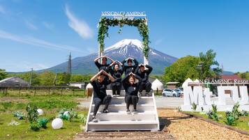 A group of people posing on a set of stairs with a sign reading "VISION CLAMPING Resort & Spa" and a mountain in the background.