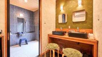 A modern bathroom with two sinks, a shower, and a mirror.