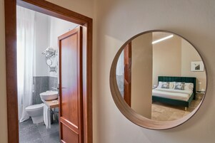 Un baño con inodoro, lavamanos y perchero para toallas.