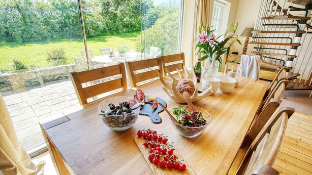 A dining table with seafood, a wooden chair, and a view of a garden.