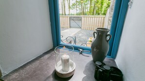 A candle in a glass holder on a windowsill, a vase, and a pair of binoculars. - Ysgubor Wennol (Swallow Barn) -  a cosy fire that sleeps 4 guests  in 2 bedrooms (Llanfairpwll)