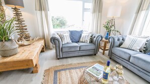 A modern living room with a grey sofa set, a wooden coffee table, and a woven rug. - Tideaway -  a coastal that sleeps 4 guests  in 2 bedrooms (Trearddur Bay)