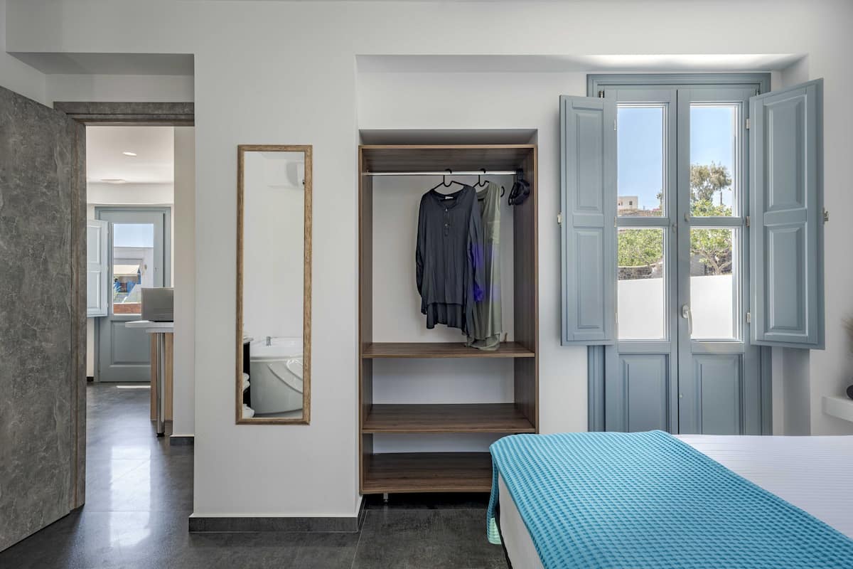 A bedroom with a bed, a wardrobe, and a window.