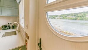 Eine Küche mit Blick auf einen Fluss und Grünflächen.