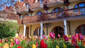 A multi-story building with a red-tiled roof and balconies. - Ágnes Hotel (Hévíz)
