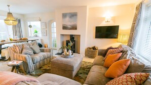 A cozy living room with a fireplace, comfortable seating, and a television.