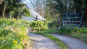 A rural pathway leading to a stone house with a metal gate. - Easter Cabin -  a remote that sleeps 4 guests  in 2 bedrooms (Moelfre)