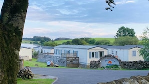 A row of mobile homes with a stone wall entrance and a sign welcoming to Heron View.