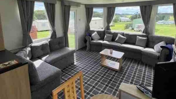 A spacious living area with a sofa set, a coffee table, and a TV.