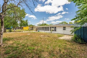 A residential property with a large backyard, a garage, and a small shed. - Studio with a Queen bed, daybed, private bathroom, kitchenette, workspace, and fast Wi-Fi. (Orlando)