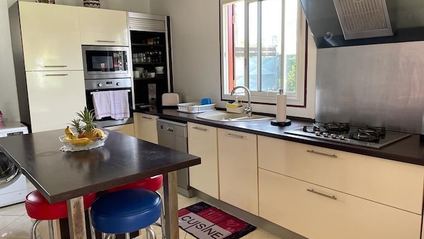 Une cuisine avec un coin repas, comprenant une table, des chaises et une fenêtre.